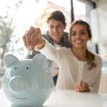 Nasmejan par štedi novac u kasicu prasicu, planirajući sigurnu budućnost kroz investiranje u dobrovoljni penzioni fond za mirnu starost